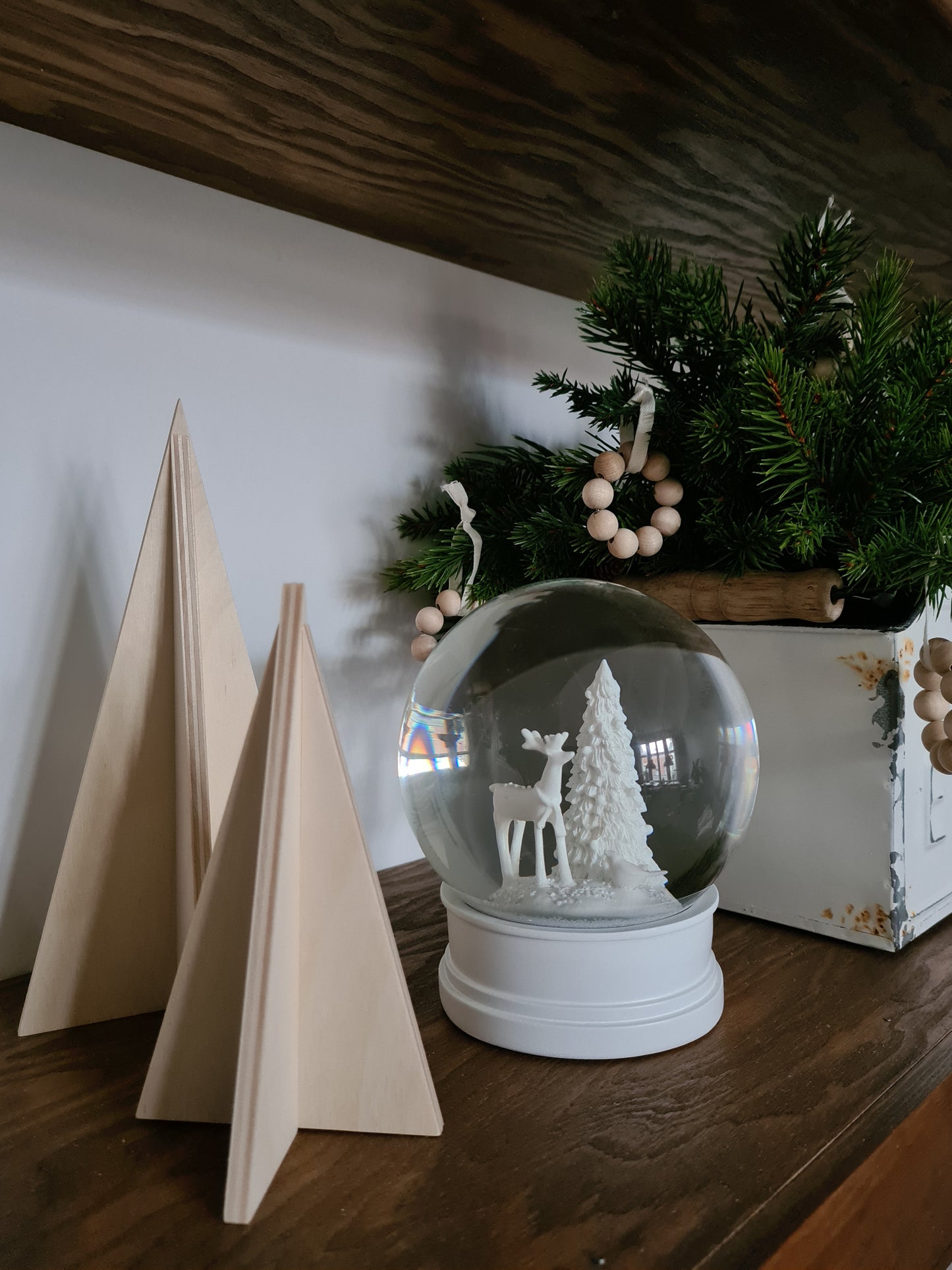 2-er Set Steckbäume dekoriert auf Regalboden mit Schneekugel und Tannenzweigen